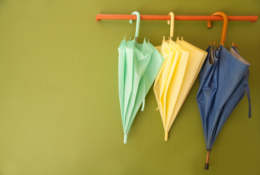 umbrella hang on hanger of green wall